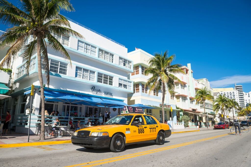 A-taxi-drives-past-restaurants-on-the-tourist-strip-of-Ocean-Drive-Miami